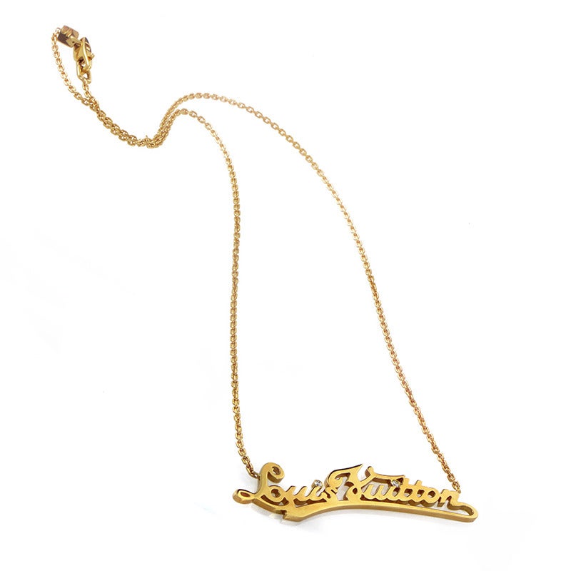 Classically designed and impeccably crafted, this charming 18K yellow gold necklace from Louis Vuitton boasts an impressive pendant in the shape of the brand’s name subtly accented with diamonds.
Included Items: Manufacturer's Box

Approximate