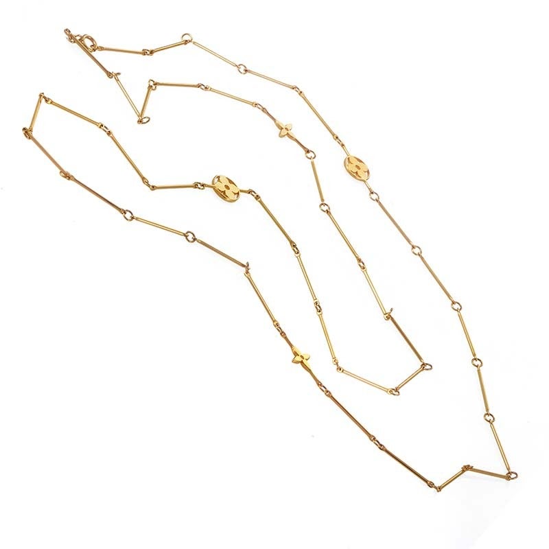 Comprised of delicate rods of 18K yellow gold attached with tiny hoops, this offbeat necklace from Louis Vuitton offers an unpredictable shape, with three flower-shaped decorations along the way.