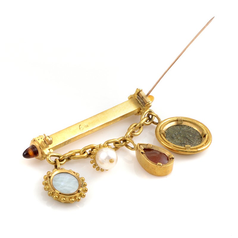 This decadent design from Elizabeth Locke is sure to please! The brooch is made of 18K yellow gold and boasts four hanging motifs including gemstones, a pearl and an ancient coin.