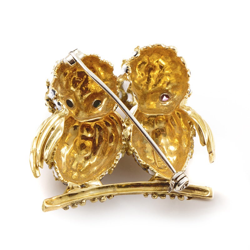 Featuring two gorgeously embellished owls standing on a branch, this fashionable brooch offers dazzling, luxurious look. It’s made of attractive 18K yellow gold and one of the owls features eyes set with ruby stones while the other one boasts