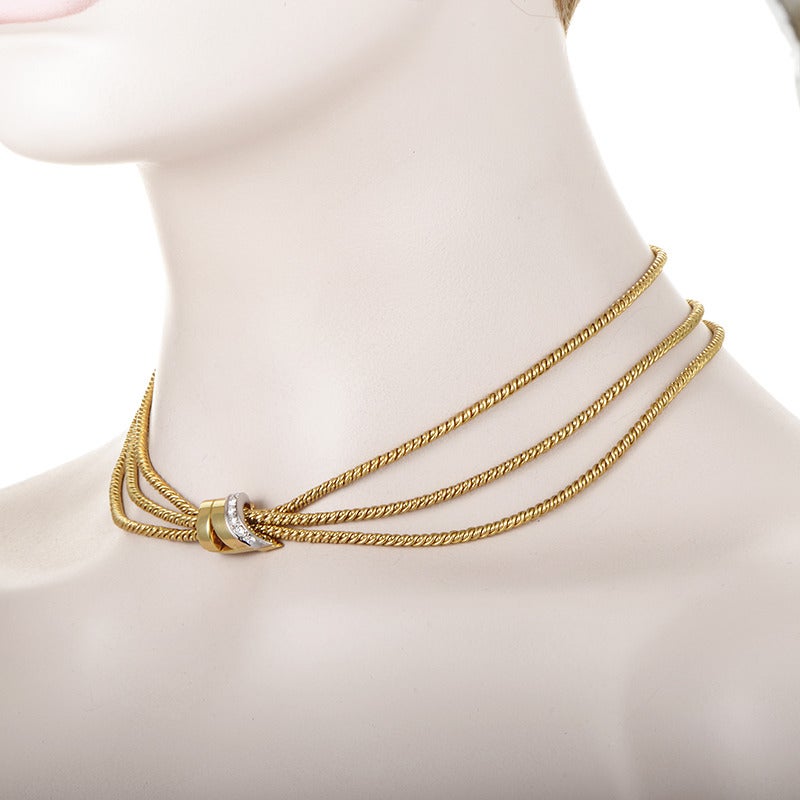 Take your style to the next level with this delightful necklace from Pomellato. The necklace boasts three woven 18K yellow gold strands which come together at the elaborately designed clasp. It is made of yellow gold as well and is accented with