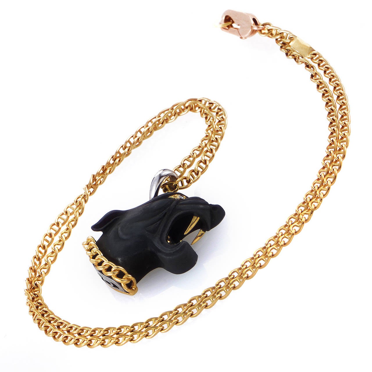 Brilliantly contrasting the delightful blend of 18K yellow and white gold, the matt black panther head pendant of this magnificent necklace from Carrera y Carrera boasts two delicate diamonds as eyes, while its collar and fangs shine with that