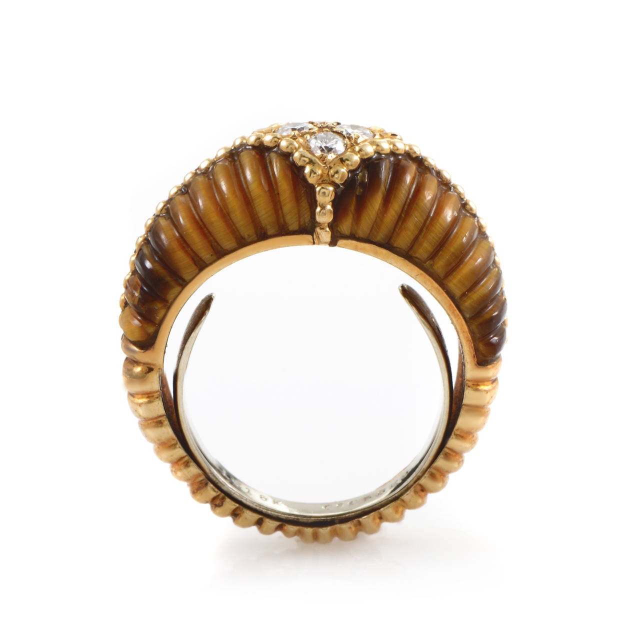 With its wonderful change in nuance and a compelling overall tone, the tiger eye stone is fitted perfectly into this harmonious ring from Van Cleef & Arpels embellished with 0.17ct of diamonds, its fluted design matching that of the 18K yellow gold