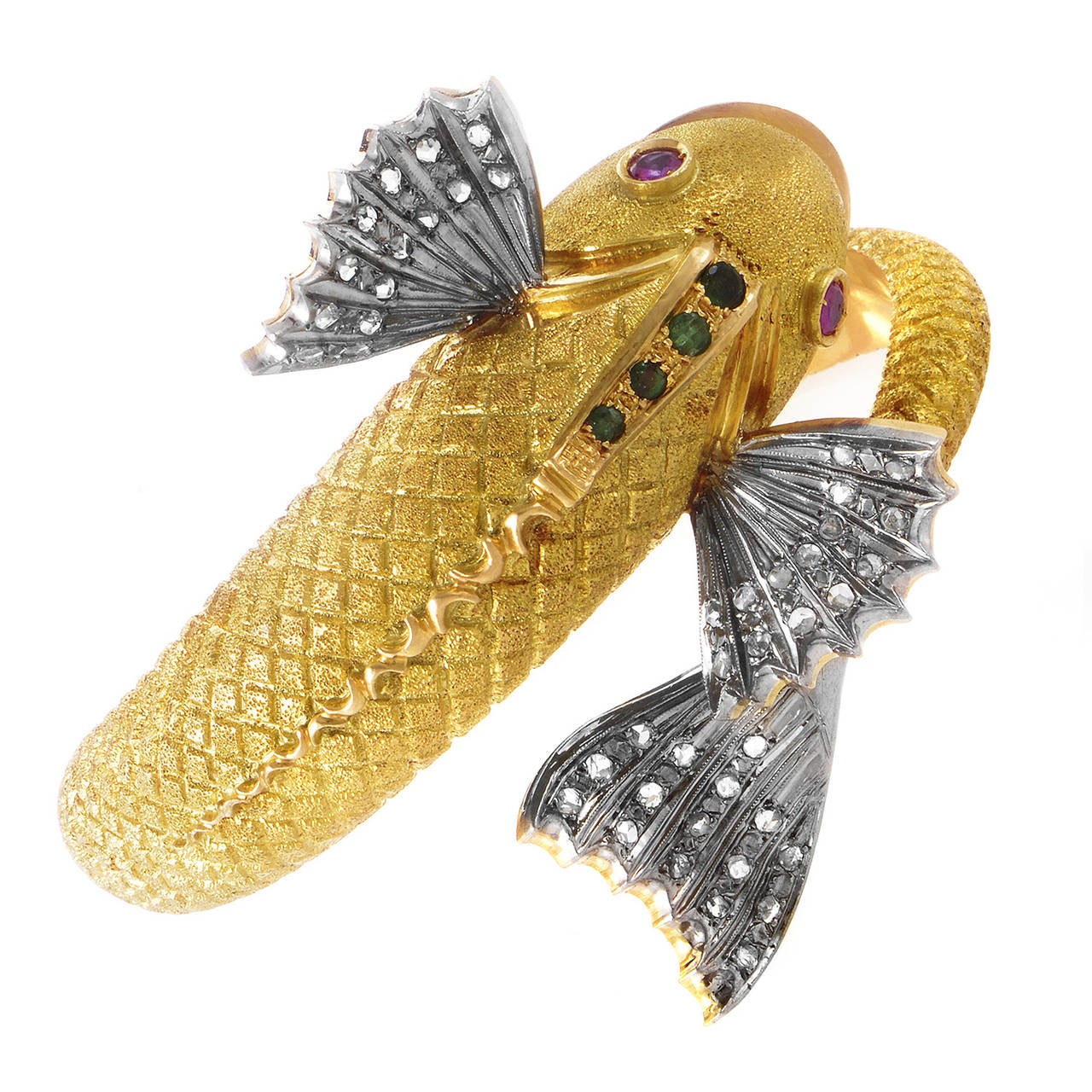 Feast your eyes upon the intricate design of this magnificent bangle bracelet. The bracelet is made primarily of 18K yellow gold, but the fish boasts white gold fins set with diamonds. Lastly, ruby eyes, and emerald accents complete this decadent