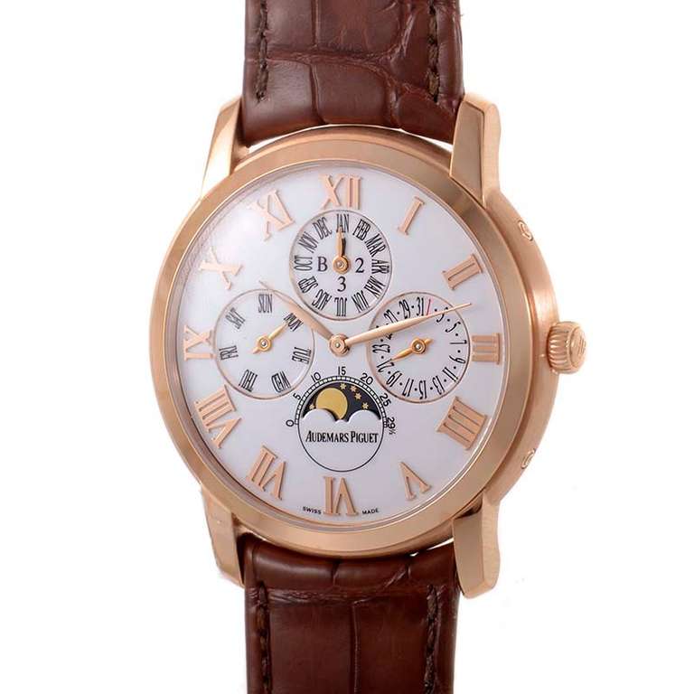 Limited edition Audemars Piguet 18K rose gold wristwatch. Displays hours, minutes, perpetual calendar, date, leap year, month, day-of-month, and moon phase on a white dial. Lastly, the watch has a brown alligator leather strap with a matching rose