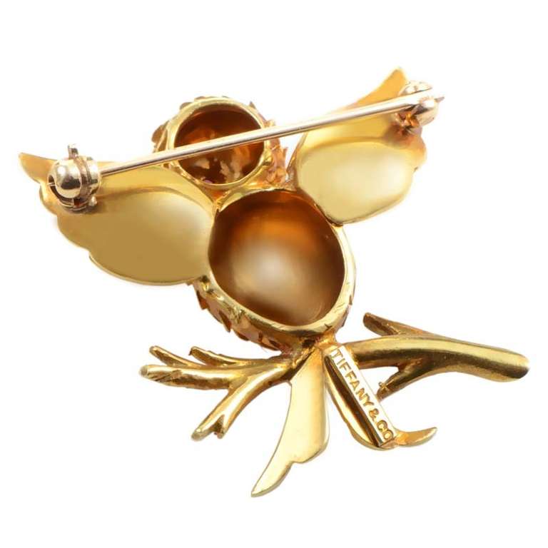 Playful and unique, this custom designed pin from Tiffany & Co. is an absolute delight! The pin is made of 18K yellow gold and depicts a cuckoo bird perched atop a branch. Lastly, the bird has a single, glimmering ruby eye.

Approximate