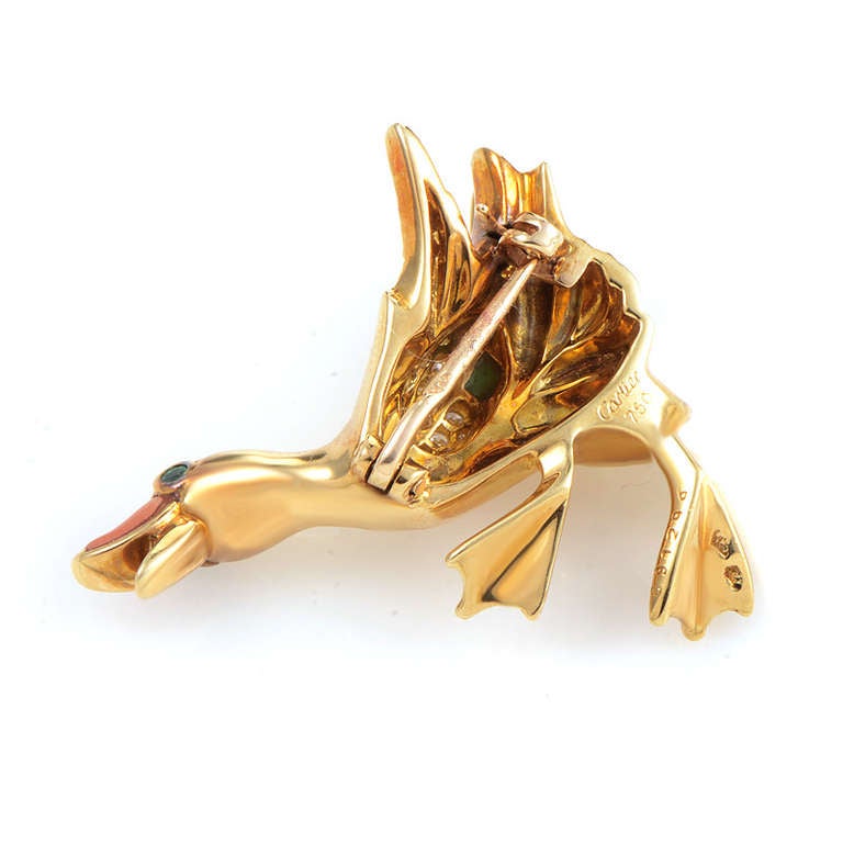 A rare collectible piece from Cartier, this brooch is perfect for the lady who desires unique jewelry with character. The brooch is made of 18K yellow gold and depicts a duck with raised wings. The bird has a beak made of bright angel skin coral