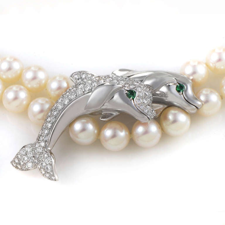 This elaborate necklace from Cartier is positively dripping with elegance. The necklace is made of a double strand of lustrous white pearls. The necklace also features a white gold pendant that depicts two dolphin motifs. Both dolphins have
