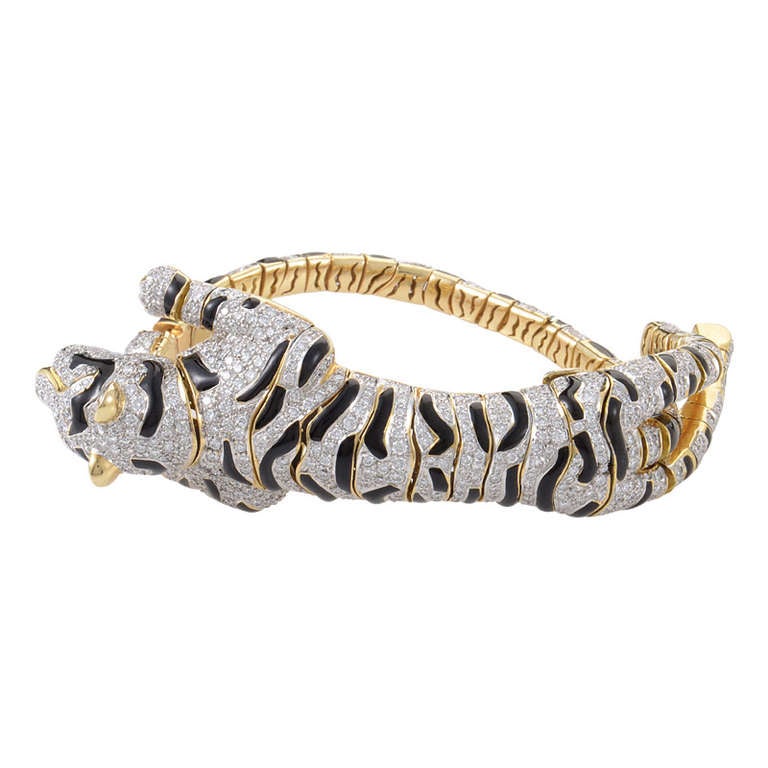 This custom designed piece of jewelry is unlike any other! This piece is multi-functional and can be worn as either a bracelet, or a very lavish brooch. The piece is made of 18K yellow gold and is shaped like a tiger ready to pounce. The tiger is