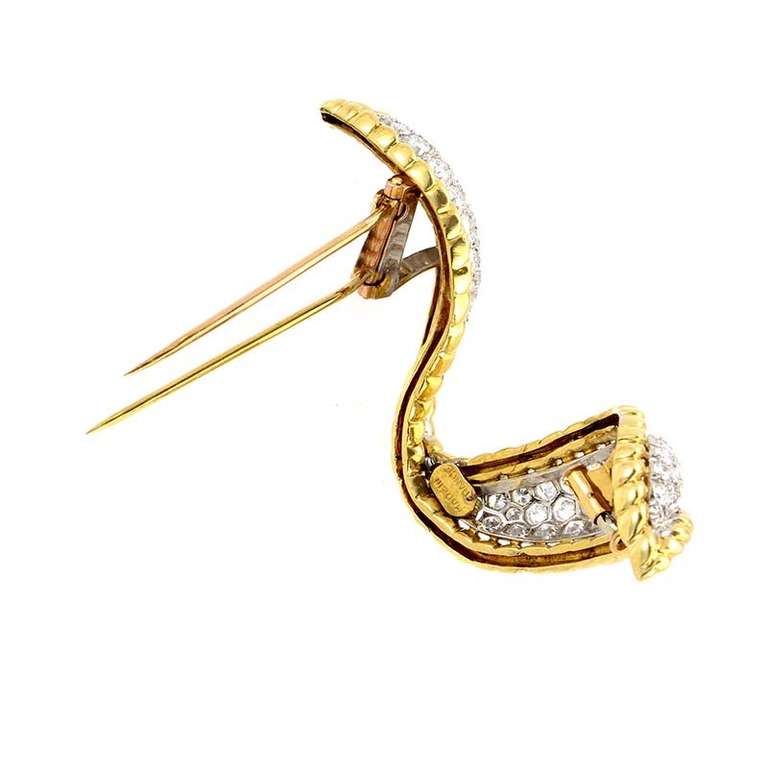 This ornate brooch from famed jewelers Van Cleef & Arpels has a distinct look that is very luxurious. It is made of 18K yellow gold and white gold. The white gold is set with an ~6.50ct diamond pave.