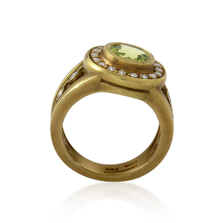 Beautifully designed and made of the finest materials, this gemstone ring from Kieselstein-Cord is absolutely divine! The ring is made of 18K yellow and boasts shanks and a bezel set with diamonds. Lastly, a single ~5.40ct peridot main stone adds a