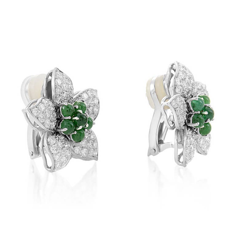 Precious gemstones make this pair of earrings absolutely spell-binding, and a must-have accessory. The earrings are made of 18K white gold and are shaped like flowers with ~4.75ct diamond paved petals. Lastly, ~3ct of emerald cabochons add a touch