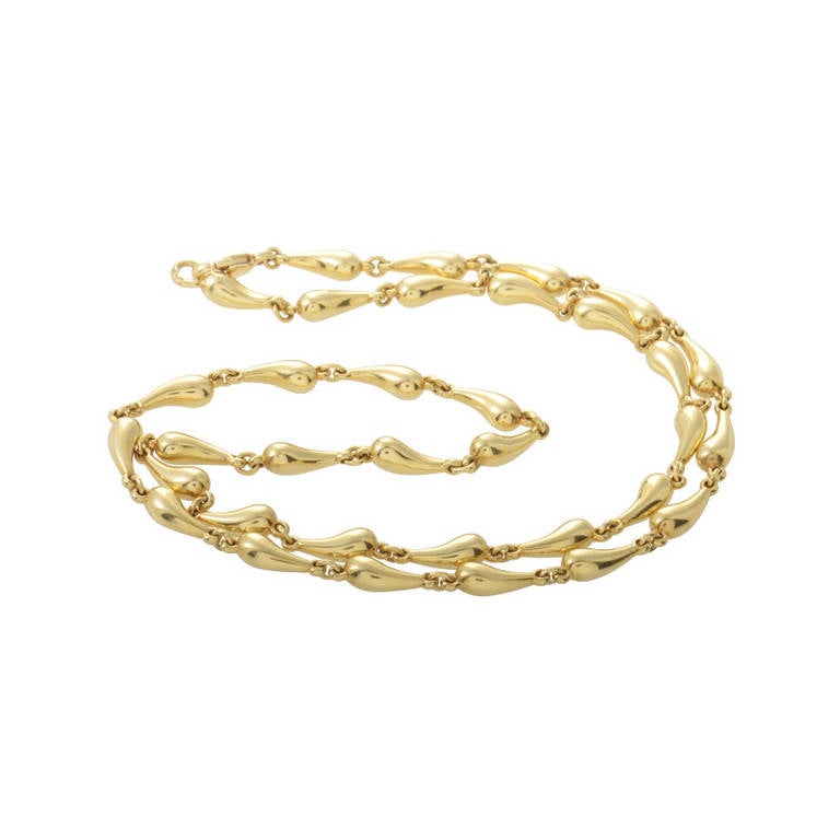 This necklace from Tiffany & Co.'s Elsa Peretti collection boast a unique look that is highly artistic. The necklace is made of 18K yellow gold and is comprised of teardrop-shaped motifs.