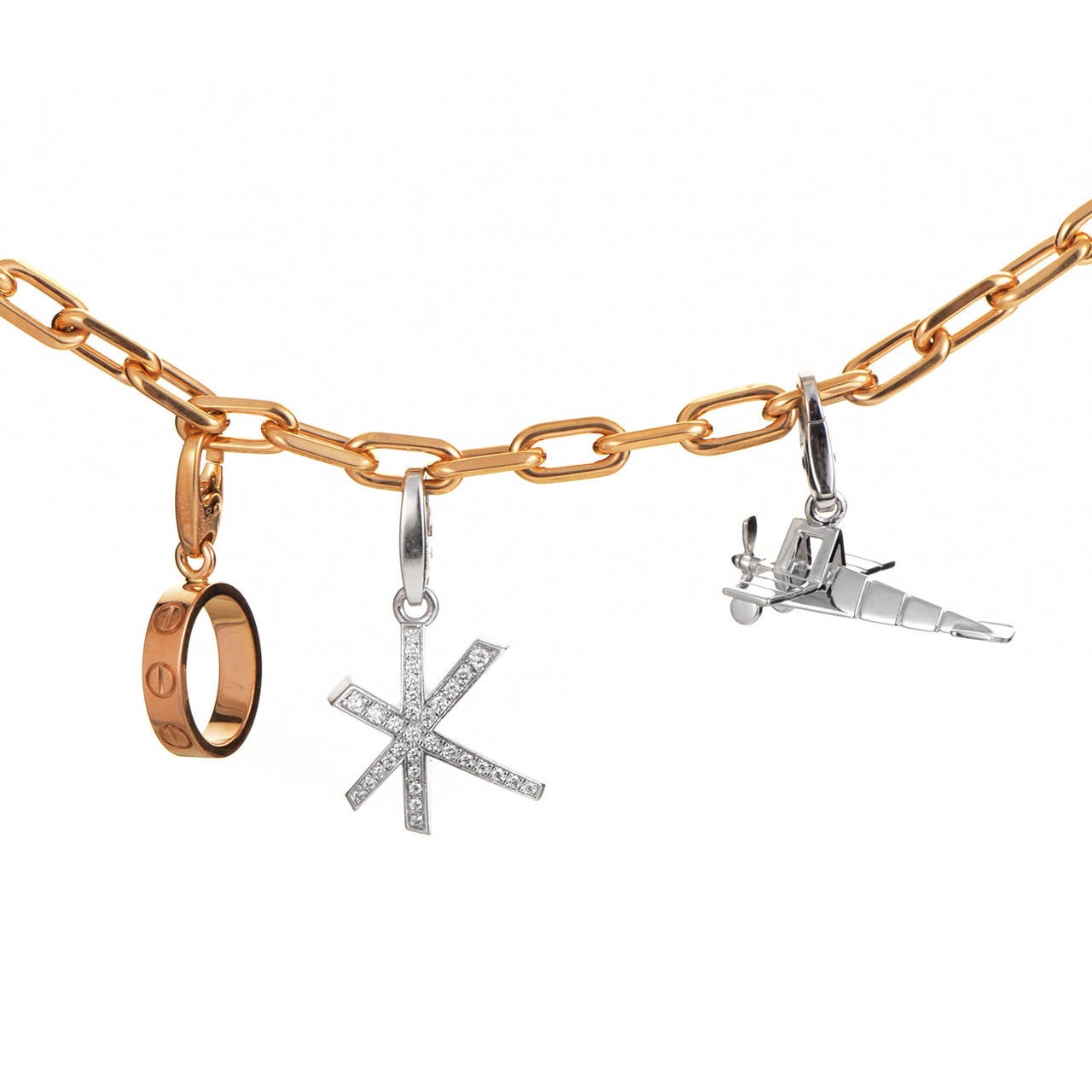 A gorgeous array of well-thought out charms makes this Cartier charm bracelet an absolute delight. The bracelet is comprised of 18K rose gold links and boasts a single rose gold charm. Two additional charms made of white gold and set with diamonds
