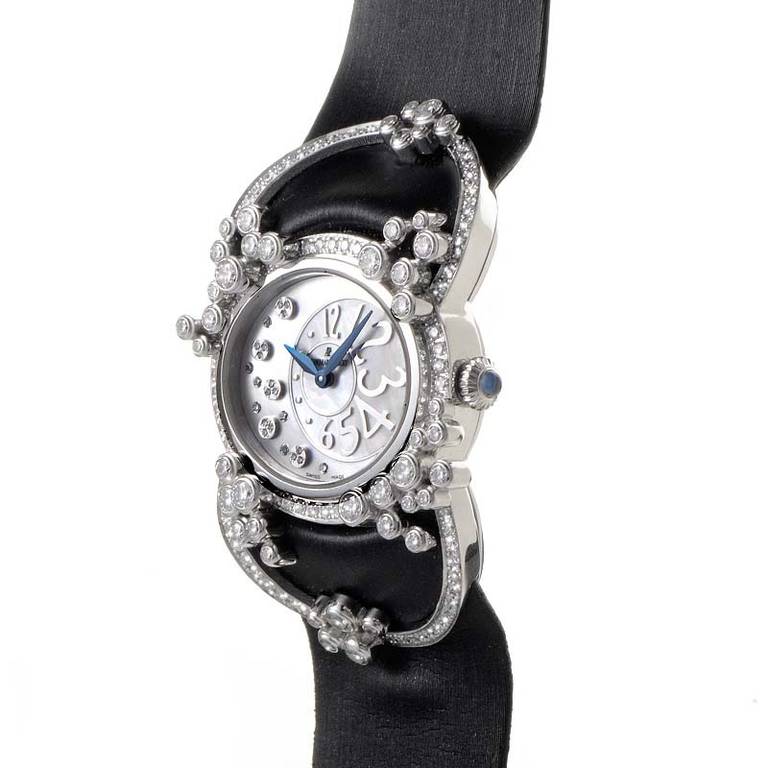 18K white gold set with 187 brilliant-cut diamonds (~2.35ct). Hours and minutes are displayed on a mother-of-pearl dial. Lastly, the black satin strap fastens with a matching white gold tang buckle.
Reference Number: 77227BC.ZZ.A007SU.01
Original