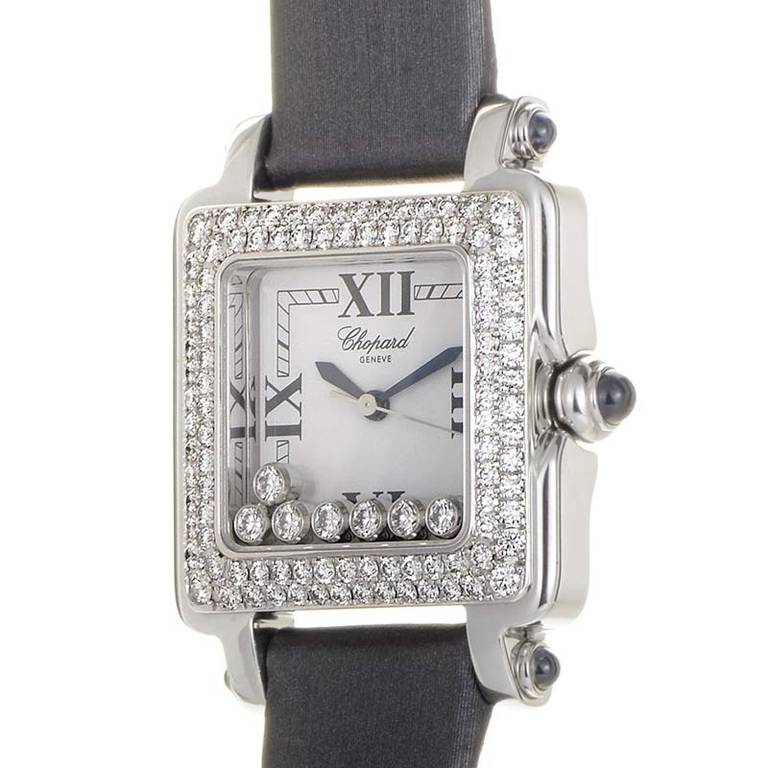 Stainless steel case with an 18K white gold bezel. The bezel is set with 104 diamonds (~1.37 ct.). Displays hours, minutes, and seconds on a white dial. Lastly, the watch has a gray satin strap that fastens with a tang clasp.Water resistant to