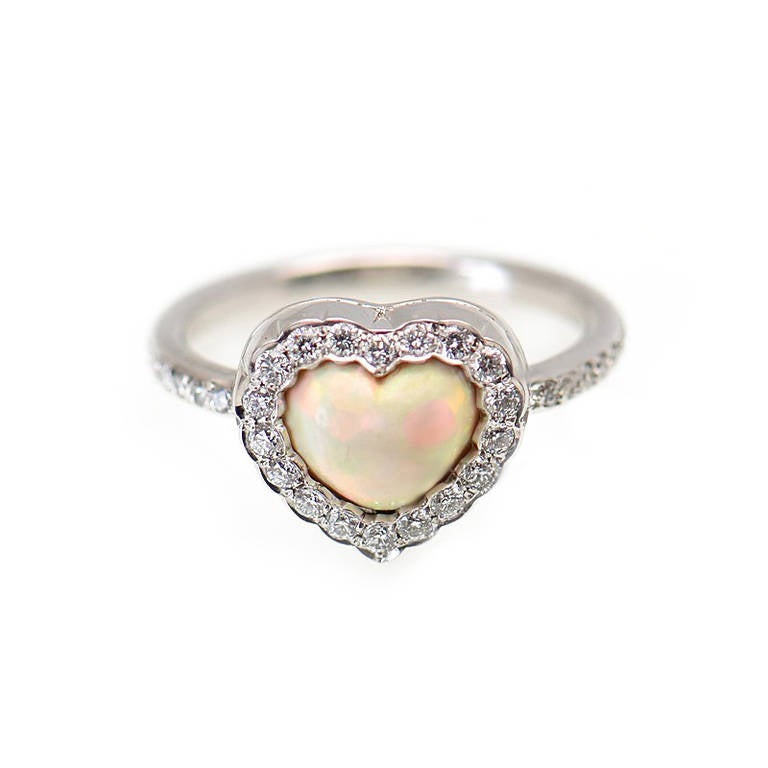 Lovely Heart ring by Dior in 18K white gold with a beautiful opal center stone, outlined with ~.35ct of diamonds. The color of the opal is white and changes color as it picks up the light.
Retail Price: $5,400.00 (Plus Tax)
Ring Size: 5.5