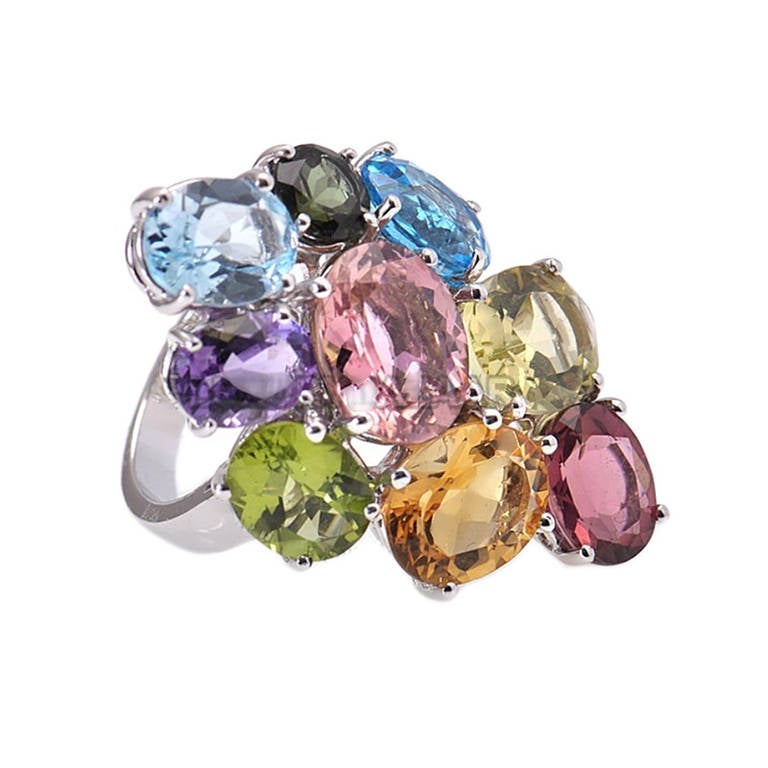 The Asprey Chaos multi-stone cocktail ring has a fantastic design that bursts with a rainbow of colors. The ring is made of 18K white gold and is set with a cluster of blue topaz, pink tourmaline, green peridot, purple amethyst and multiple citrine