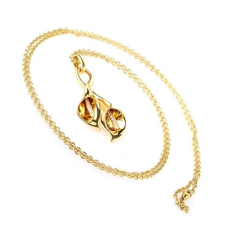 This pendant necklace from Asprey is gorgeous and feminine. It is made of 18K yellow gold and boasts a double calla lily shaped pendant set with ~.28ct of diamonds.
Approximate Dimensions:Drop of the Necklace: 20