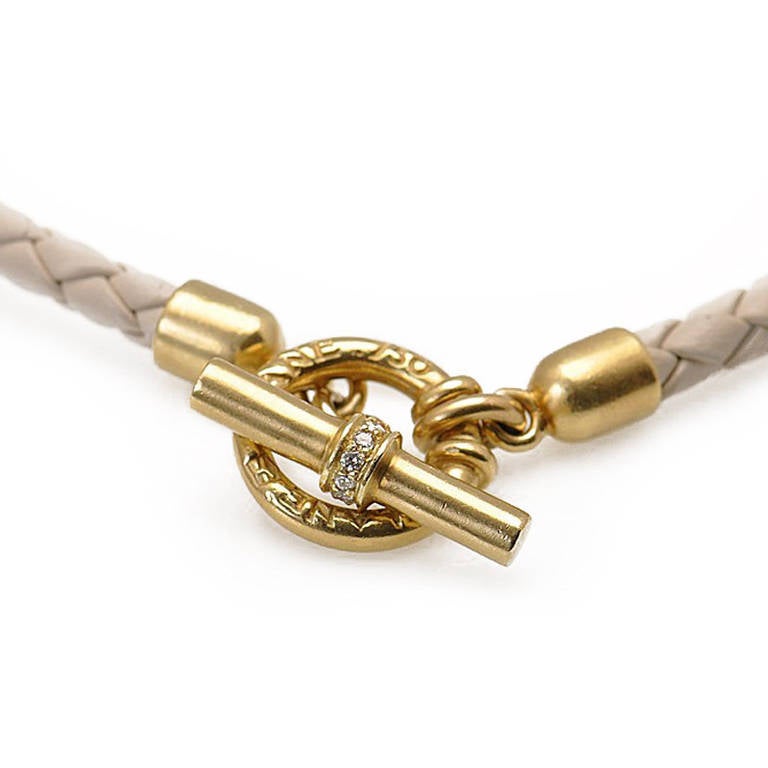 Lovely Slane & Slane leather necklace featuring ivory leather with 18K yellow gold toggle closure. The heavy toggle bar has set diamonds around the center.
This is a modern, sleek and at the same time very elegant necklace.
Retail Price: $4,900.00