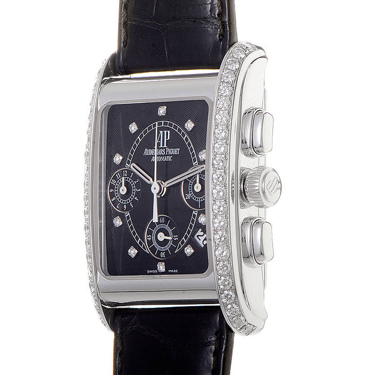 Displays hours, minutes, seconds, date, and three chronograph subdials on a black dial. The 18K white gold bezel is partially set with round-brilliant diamonds. Lastly, the black alligator leather strap fastens with a deployment clasp.
Original