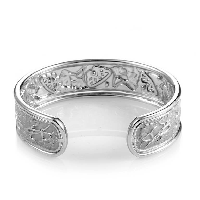 A rare treat to behold as well as to wear, this piece from Carrera y Carrera is sure to garner much attention. This cuff-style bracelet is made of ornately carved 18K white gold displaying a forest of delicate ginkgo leaves, some of which are set
