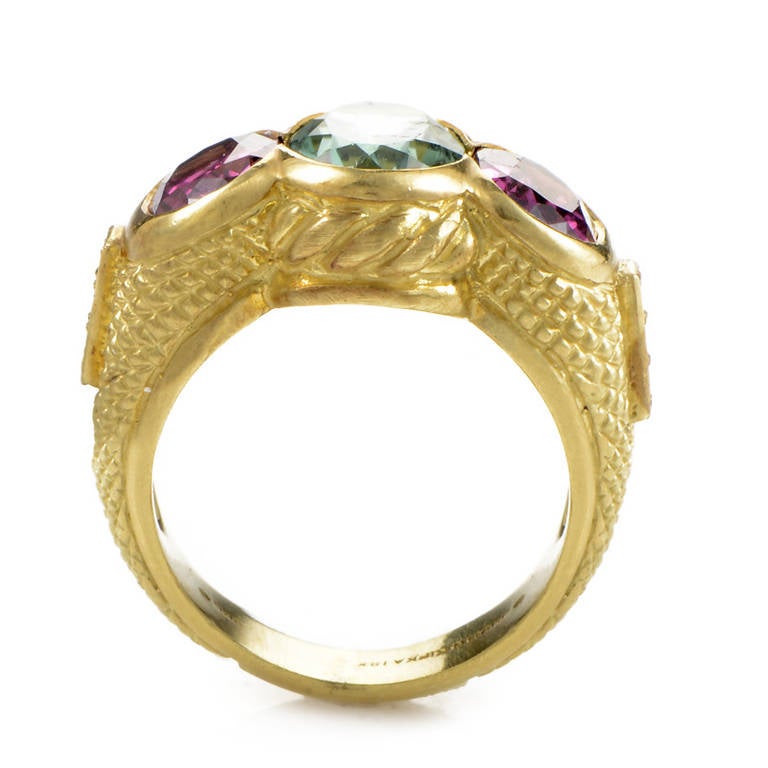 A gorgeous blend of gemstones brings this decadent golden band from Judith Ripka to life! The ring is made of carved 18K yellow gold and is set with a green tourmaline main stone flanked by two pink tourmaline side stones. Lastly, the shanks are