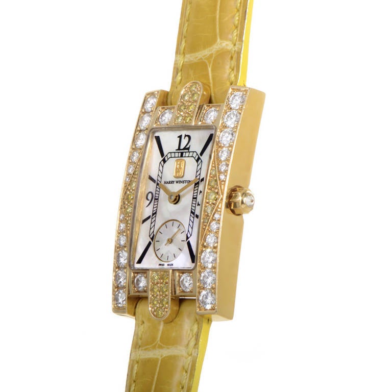 Harry Winston lady's 18k yellow gold quartz wristwatch with dazzling yellow and white diamond-set bezel. White mother-of-pearl dial displays hours, minutes, and seconds in a sub-dial. Embossed yellow alligator leather strap with deployment clasp.