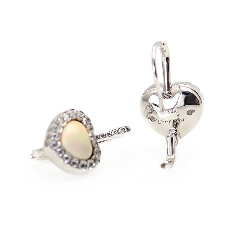 Lovely Heart earrings by Dior in 18K White gold with a beautiful Opal center stone, outlined with diamonds around the heart and on the post.
The color of the Opal is white and reflects different colors as it catches the light.
Diamond Carat