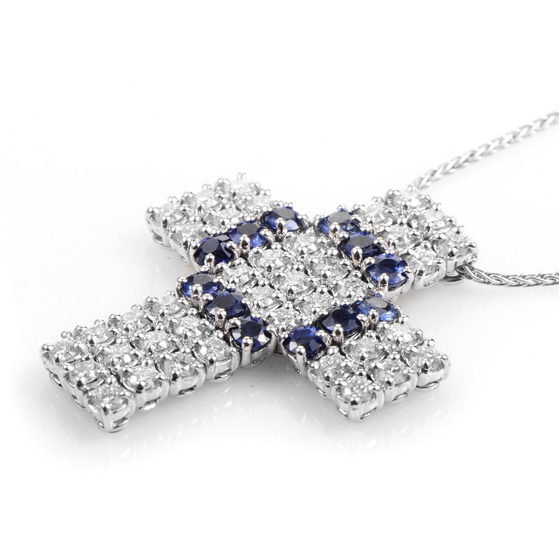 The beautiful blue of sapphires paired with the pristine purity of white diamonds makes this pendant necklace a truly excellent piece. The necklace is made of 18K white gold and features a cross-shaped pendant set with a glittering ~1.37ct diamond
