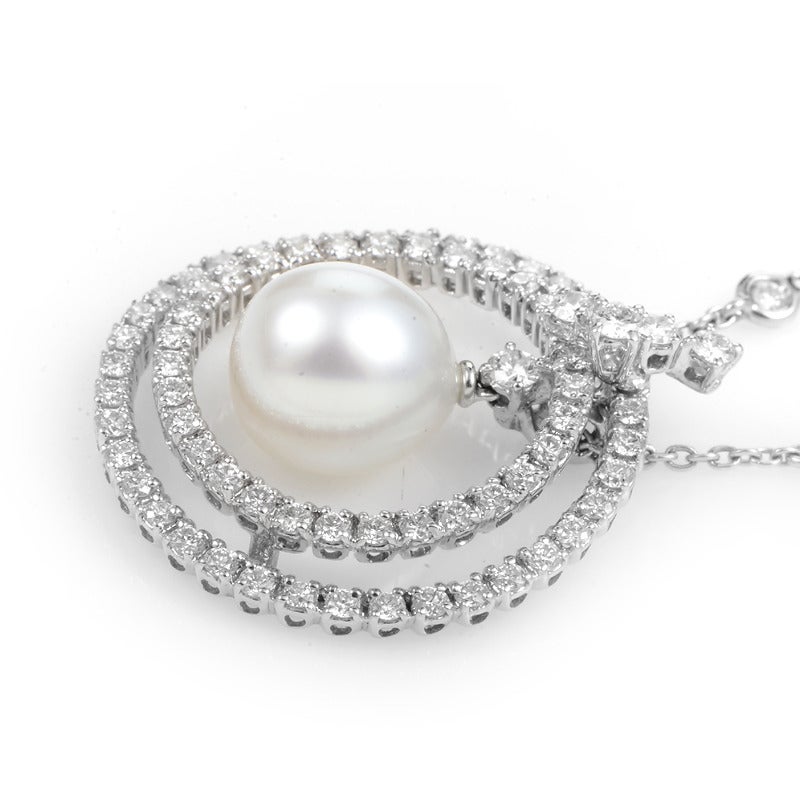 This luxurious pendant necklace would look fabulous gracing any woman's decolletage. It is made of 18K white gold and features an openwork pendant set with glittering white diamonds. Lastly, a lustrous white pearl hangs inside of the