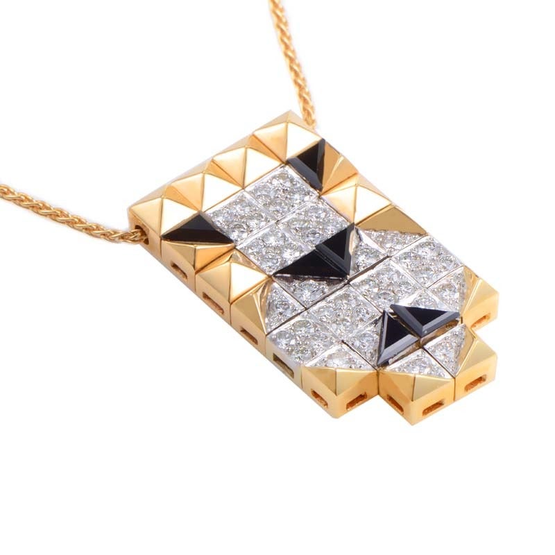 The fiercely unique design of this pendant necklace from Engima by Bulgari is truly outstanding! The pendant necklace is made primarily of 18K rose gold with a white gold accented pendant. Lastly, the pendant is set with black onyx and white