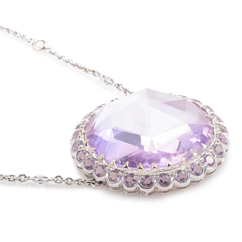 This pendant from Laura Munder has a sweet and feminine look. The necklace is made of 18K white gold and features a fairly large pendant set with a beautiful pink mother of pearl accent. Lastly, surrounding the mother of pearl are petite amethyst