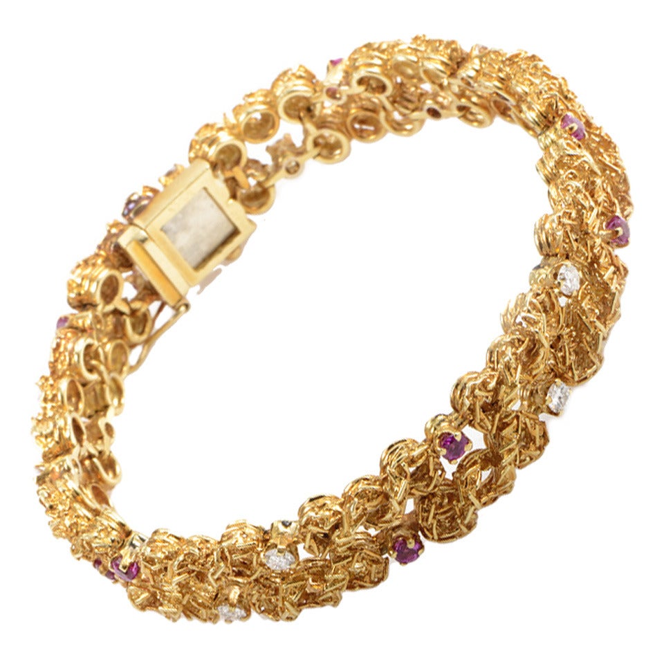 Intricately threads of 18K yellow gold weave a looping stronghold of luxurious design in this magnificent bracelet from Tiffany. Tucked within the dense foliage of precious metal are settings of 0.70ct rubies and 0.75ct diamonds.