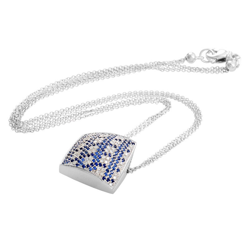 A pretty pave of diamonds and sapphires is the hallmark of this exceptional piece from Piero Milano. The necklace is made of 18K white gold and features a dangling pendant made of the same material. Lastly, the pendant is set with ~.69ct of diamonds