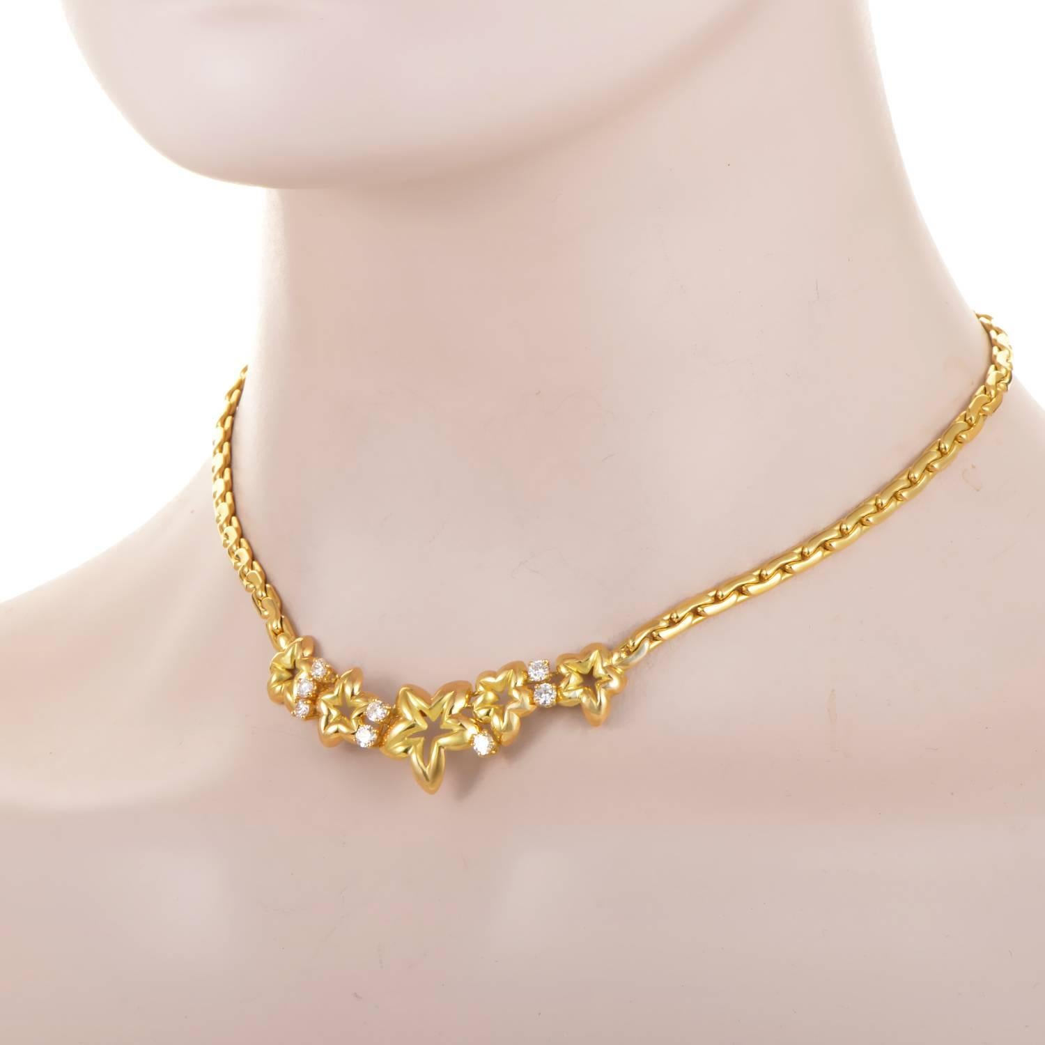 The 18K Yellow Gold chain begins its drop in bold form, its smooth links boasting integrity. The chain rolls into a stretch of more intricate design, as the metal takes on the shape of flowers, their petals granting the motif a star-like quality.