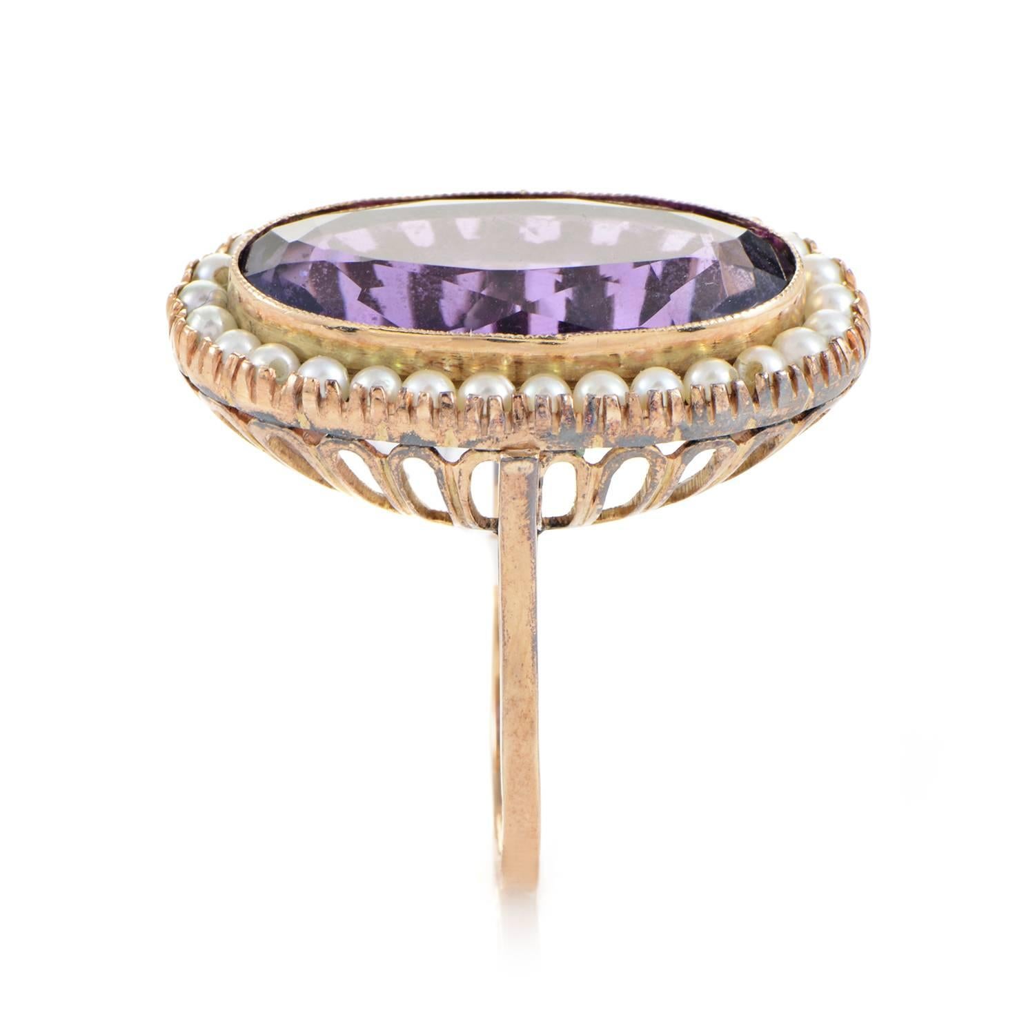 das 14-karätige Gelbgold steigt sanft und konvex zu einem schillernden Plateau aus Amethyst und Perle an. Der große Schliff des Amethysts dominiert die Bühne, und die Perlen kräuseln sich in einem ozeanischen Rhythmus um den Umfang in einem äußerst