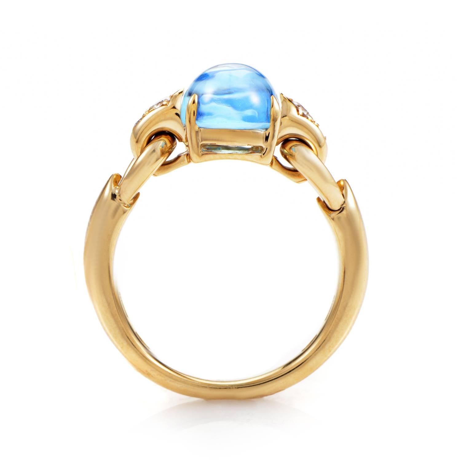 The 18K Yellow Gold band takes a pristine turn, rising from narrow beginnings into broader plains before its tide breaks into smoothly folded links. It is here at its cresting height where the ring risies into a swell of topaz, its oceanic hues