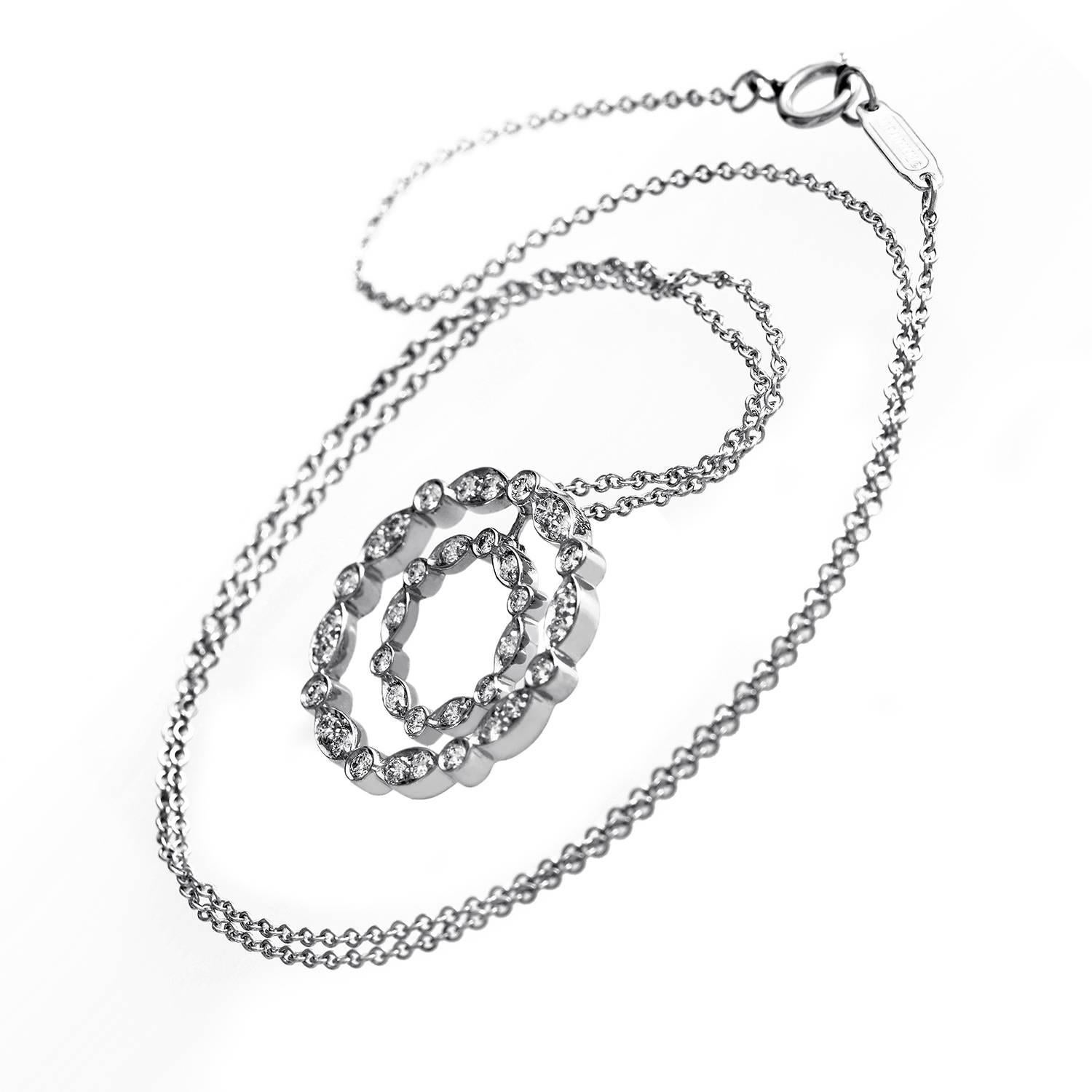 True to the refined subtlety of Tiffany elegance, this delicate platinum rolo chain is graced with a stunning duo-halo pendant. ~.75 ct of diamonds gleam from round center point bezel settings that punctuate marquise shaped settings that each hold