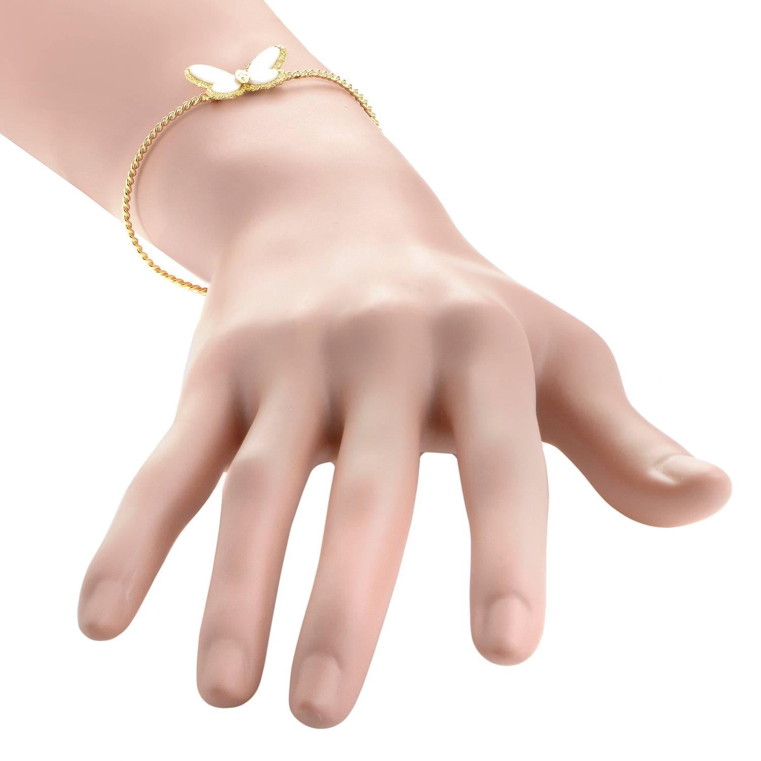 Employing an enchanting motif recurring throughout their renowned opus, Van Cleef & Arpels graced this fantastic 18K yellow gold bracelet with a lovely charm in the form of a butterfly that boasts nifty white coral and a bright central