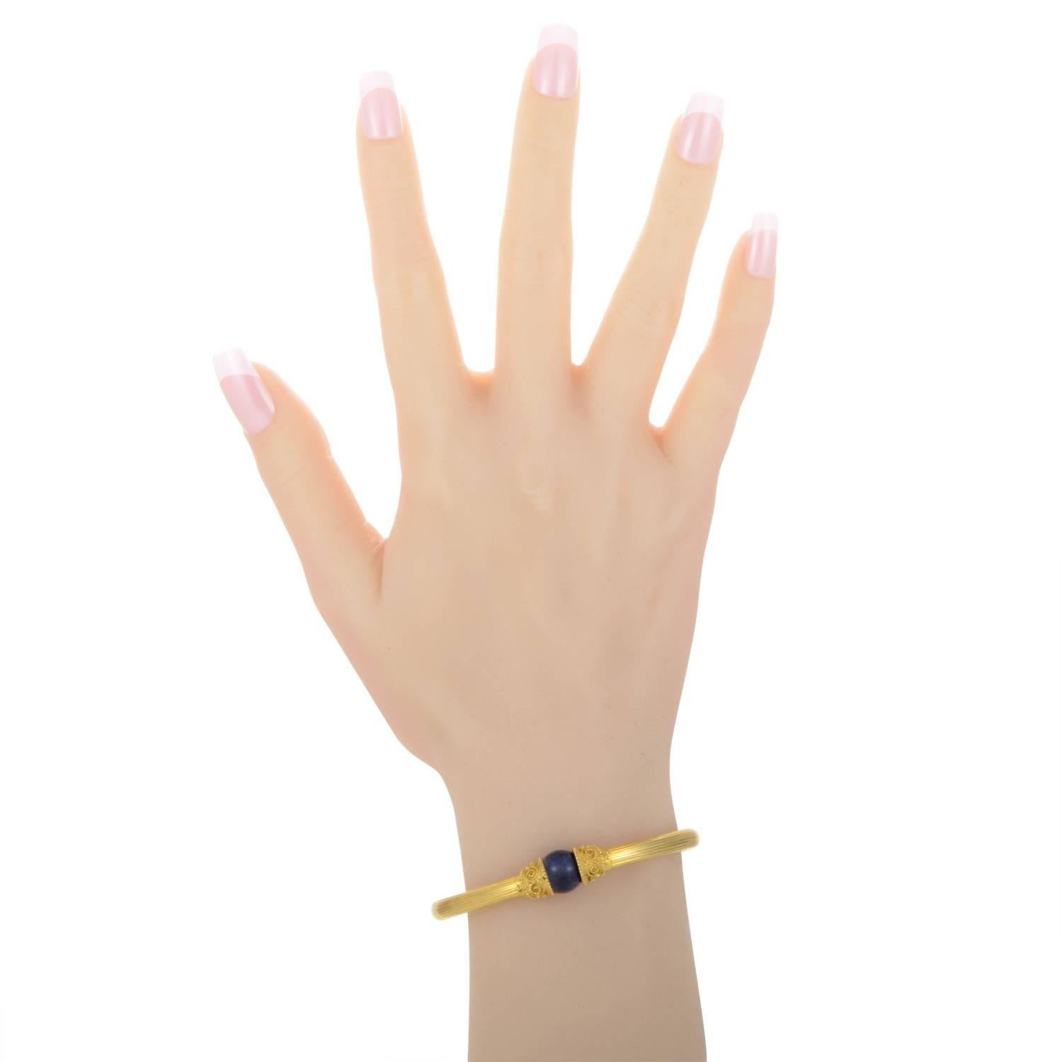 Die renommierte griechische Marke Ilias Lalaounis ist berühmt für ihre dekadenten Designs, die einen antiken Charme haben. Dieses Armband der Marke besteht aus 18 Karat Gelbgold und ist mit einer Lapislazuli-Perle verziert.
