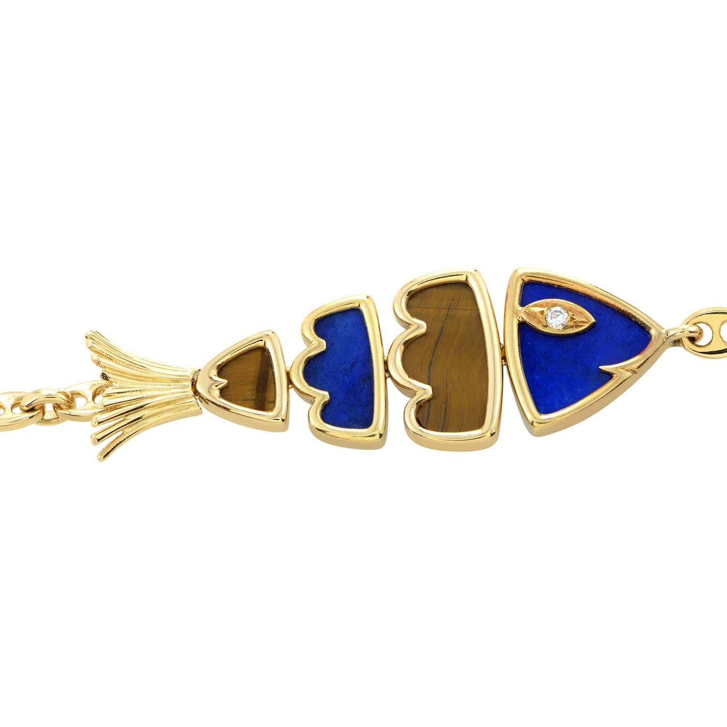 Swim in a sea of style with this posh bracelet from Van Cleef & Arpels! The bracelet is made of 18K yellow gold and features an adorable fish charm made of lapis lazuli and tiger's eye panels. Lastly, the fish looks out with a diamond eye.
Included