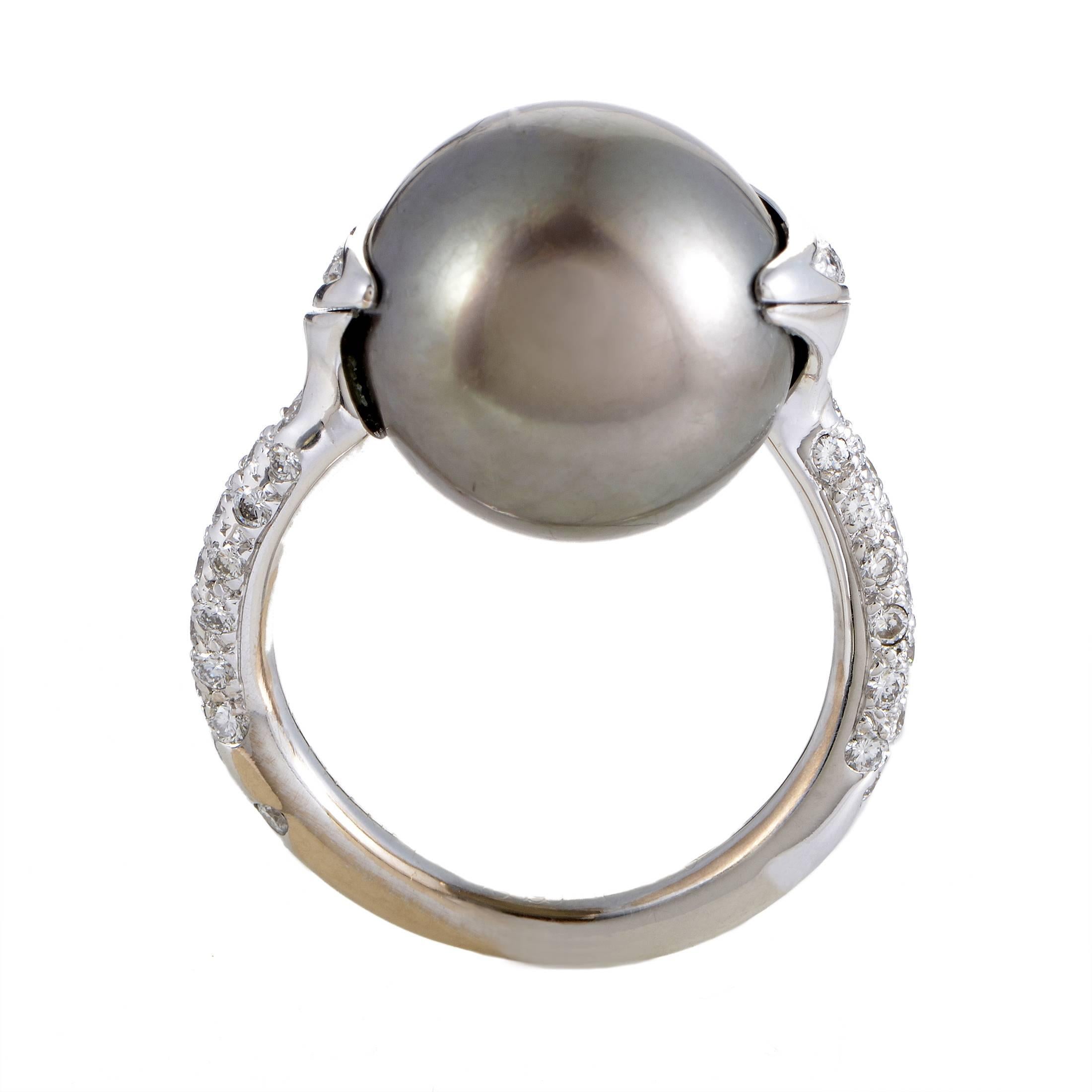 The stunning darkness and immaculately gleaming surface of the gorgeous 13.70mm Tahitian pearl brilliantly contrast the bright sparkling diamonds weighing in total 0.75ct to create a fascinating sight in this exceptional 18K white gold ring from