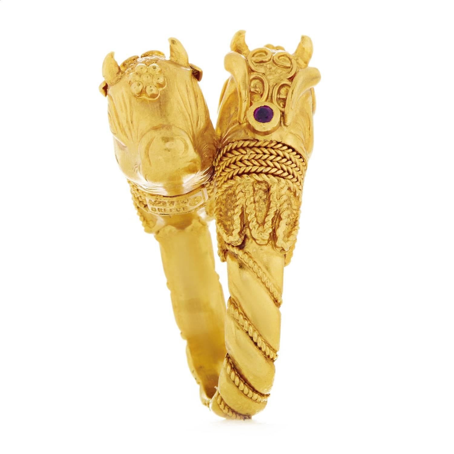Wonderfully ornate and amazingly intricate, this exceptional ring from Ilias Lalaounis boasts lavish décor upon the entire 18K yellow gold body as well as the gorgeous depictions of animals at the top, while adorned with two striking rubies for a