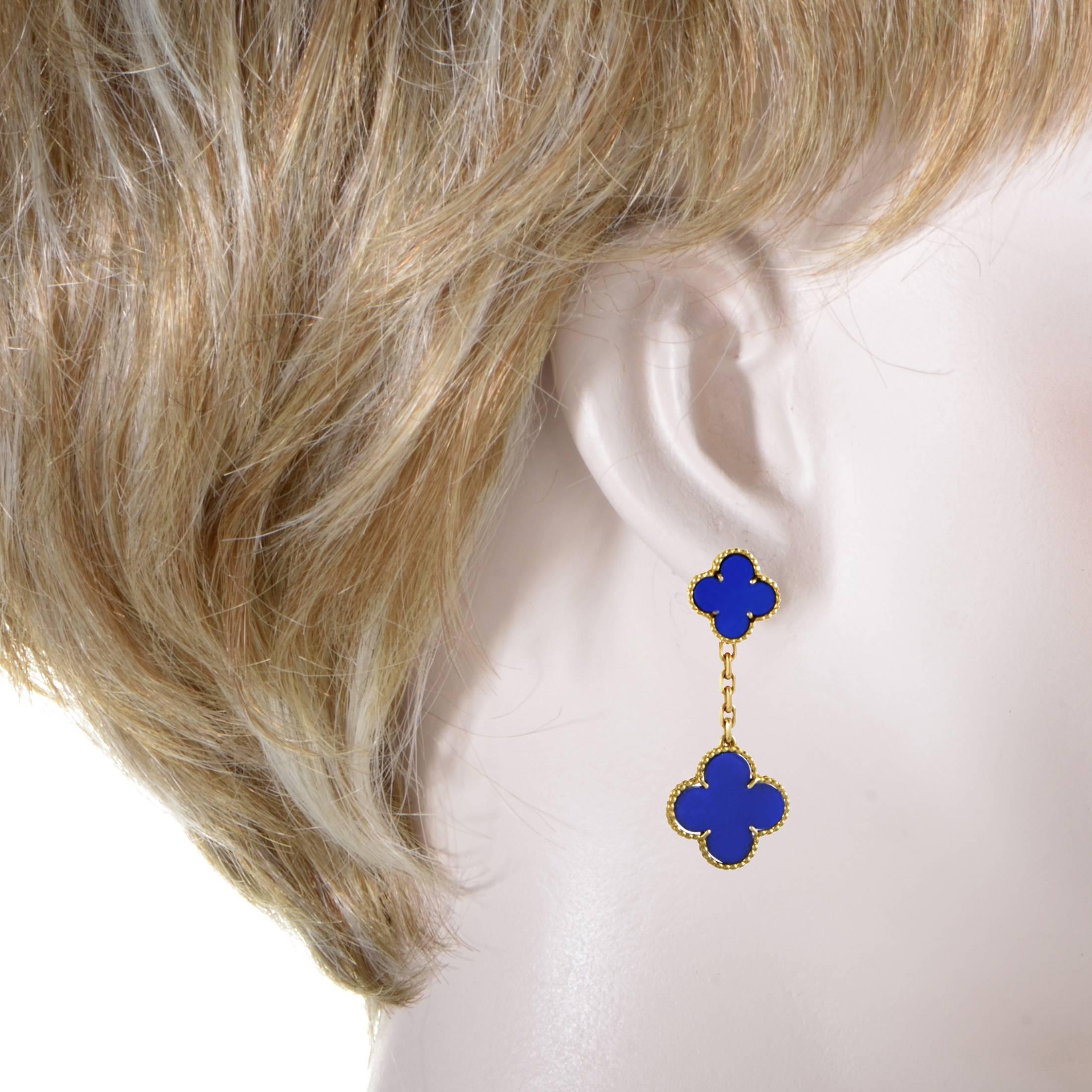 Boasting charming shapes of intricately ornamented 18K yellow gold with stunningly contrasting lapis lazuli stones of magnificent color, these extremely rare earrings from Van Cleef & Arpels are true jewels from the esteemed Alhambra