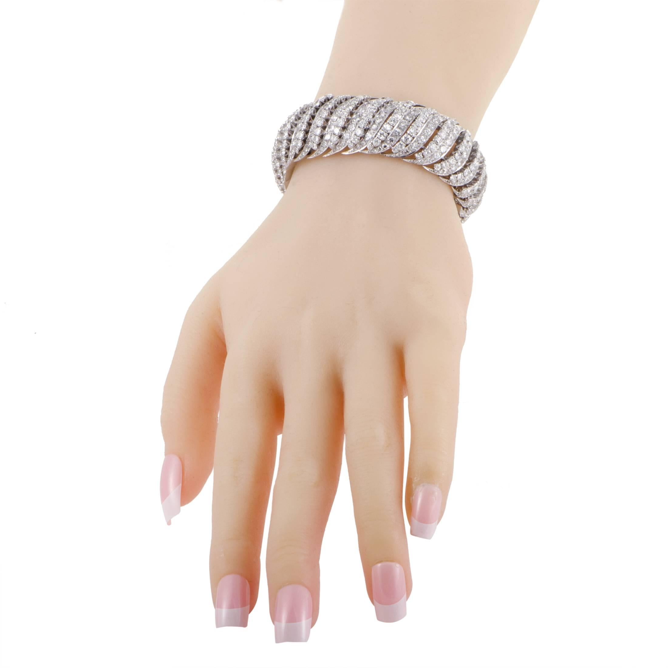 A spellbinding, pure and stylish expression of utmost prestige, this extraordinary bangle is made of intriguingly entwined platinum which is lavishly embellished with tantalizing diamonds weighing in total approximately 31.00 carats for a