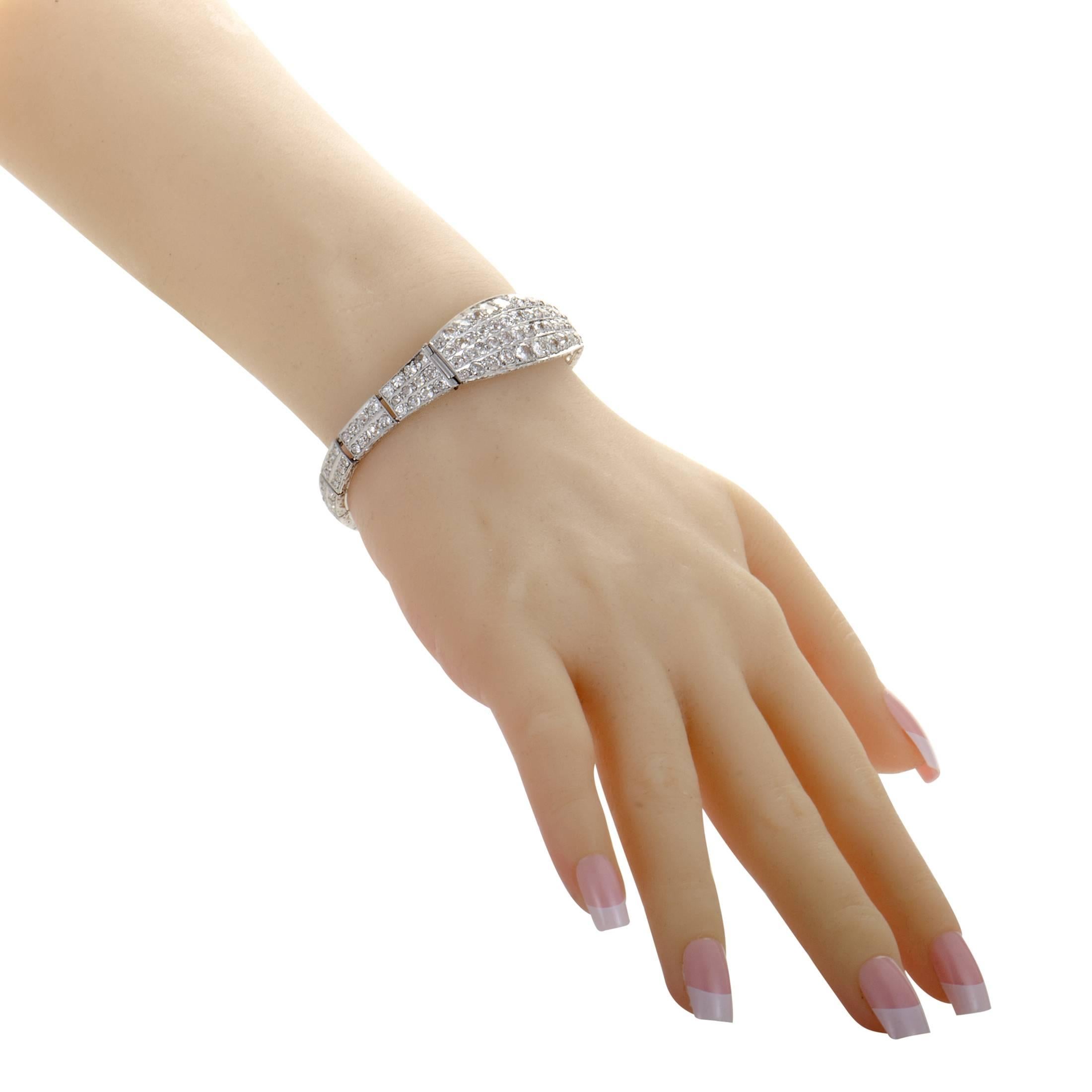 An astonishing show of pure prestige, tasteful exuberance and wonderful harmony, this dazzling bracelet is made of shimmering 18K white gold which is almost entirely paved with tantalizing diamonds weighing in total approximately 12.00 carats.
