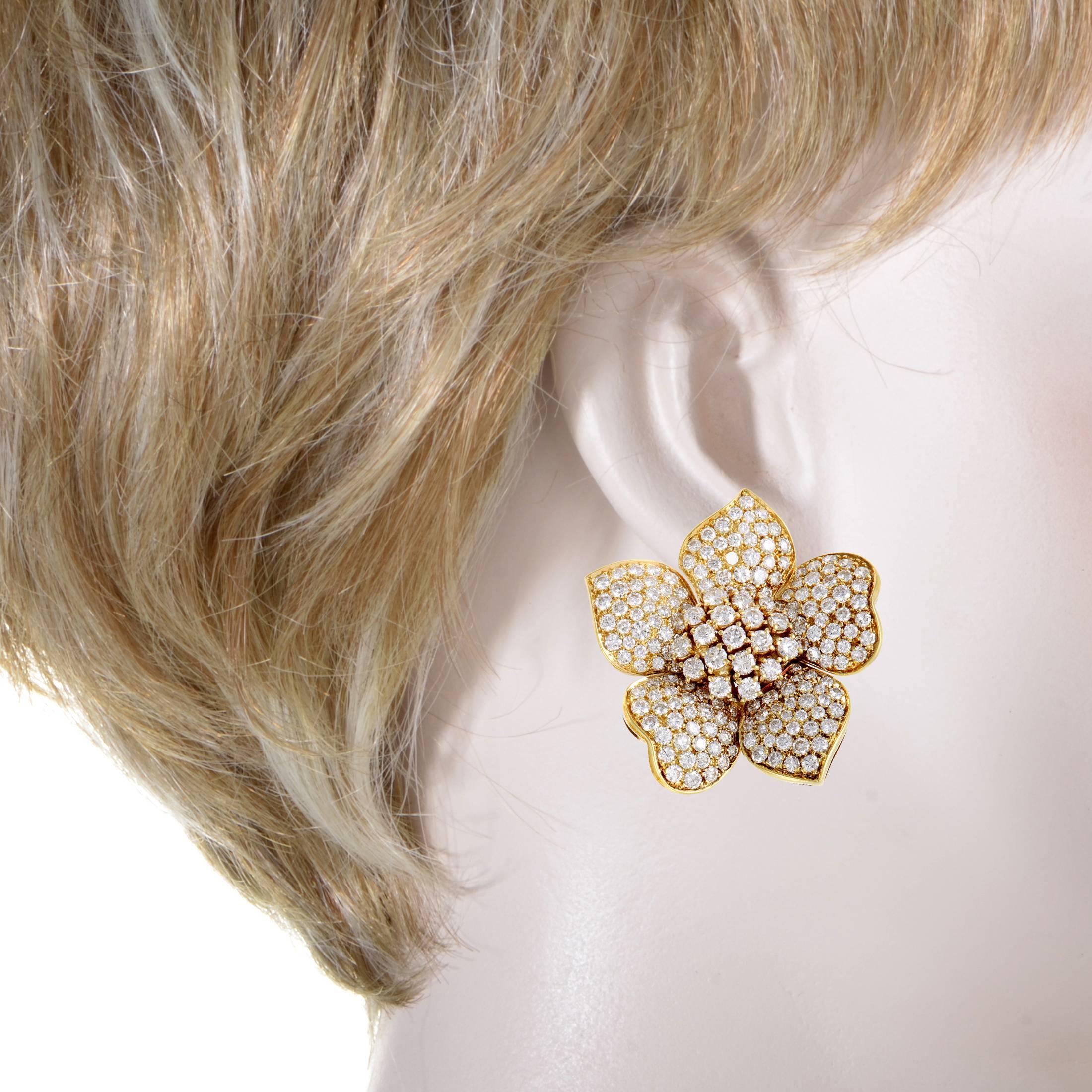 The delightful beauty of flowers is brilliantly translated into a luxurious design through glamorous combination of radiant 18K yellow gold and glittering diamonds amounting approximately to 7.50 carats in these glorious and lavish earrings.