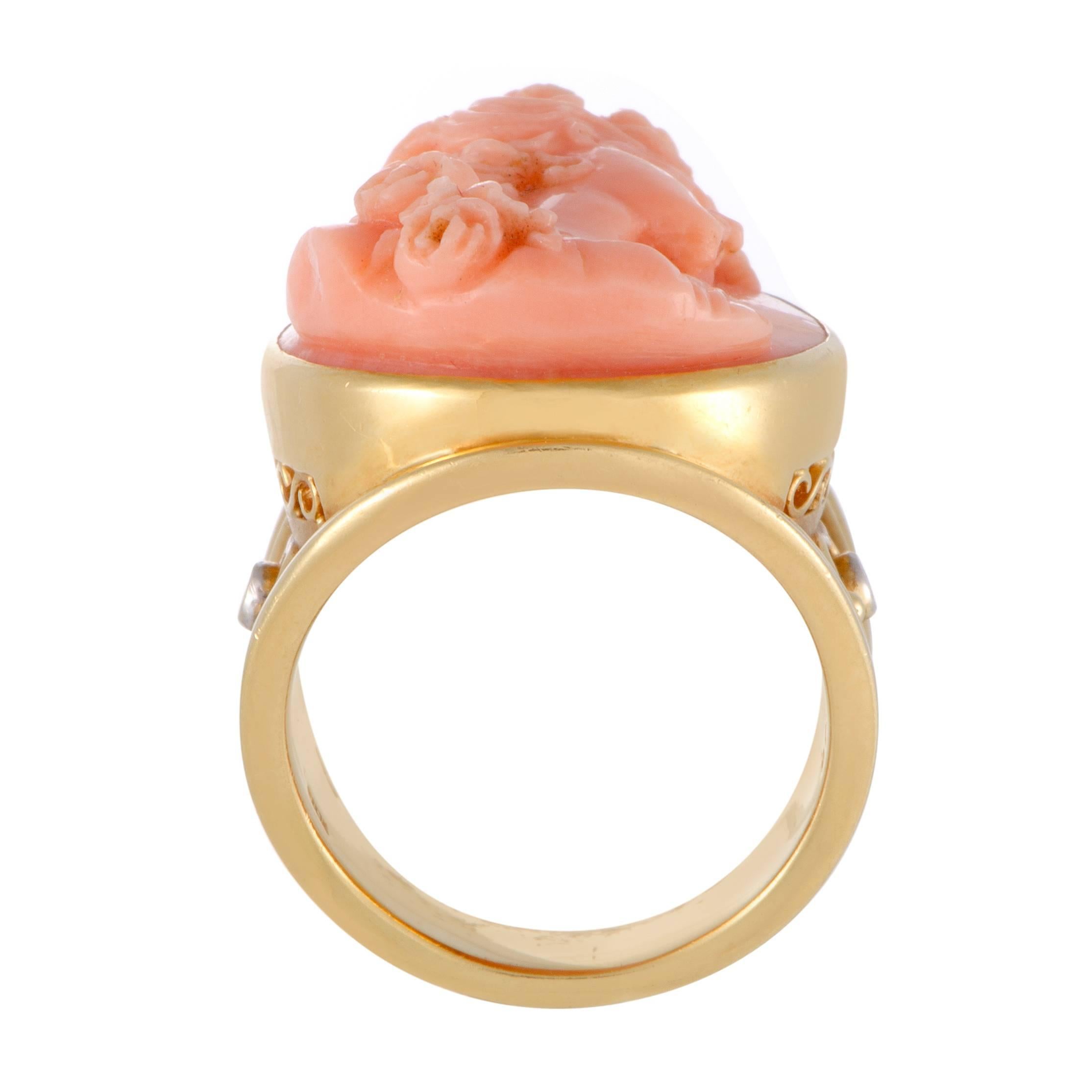 The compelling antique spirit of this magnificent ring is produced by the amazingly artistic relief carved in delightful coral stone as well as the intricately ornamented 18K yellow gold which is also embellished with 0.06ct of charming diamond