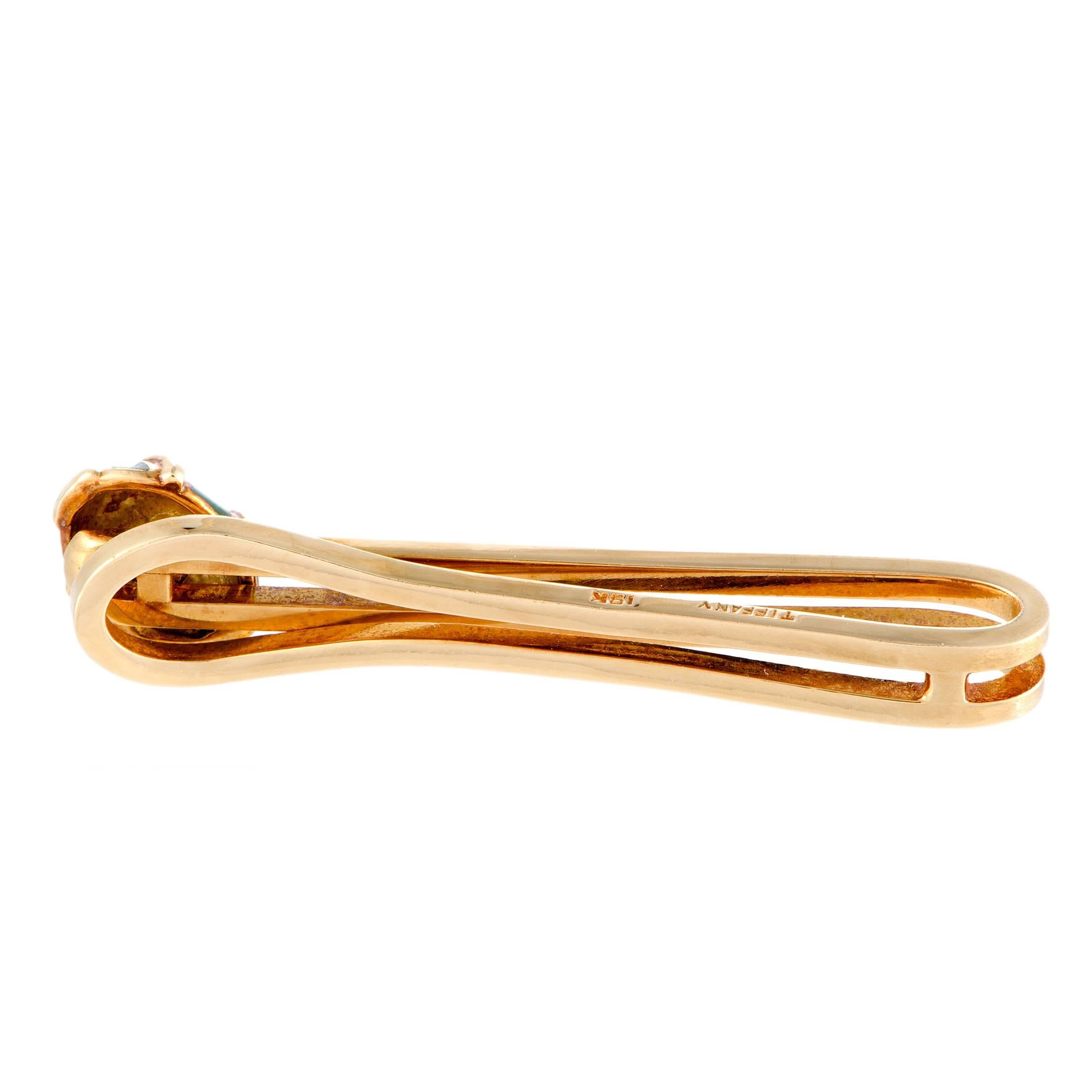A timelessly elegant and sophisticated design is given a stunning twist in the form of vividly green enamel to add bright color to the luxurious sheen of 18K yellow gold in this remarkable tie bar designed by Jean Schlumberger for Tiffany &